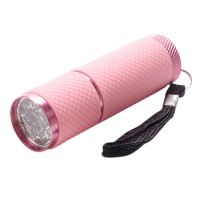 Pink flashlight with a black strap on a white background