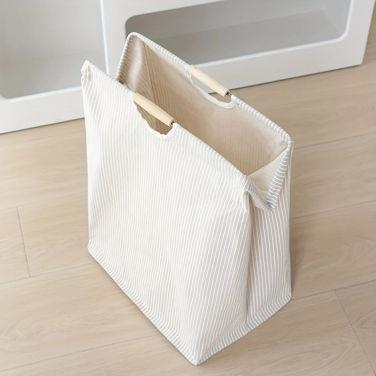 Laundry hamper featuring dual handles for easy transport and efficient home organization.